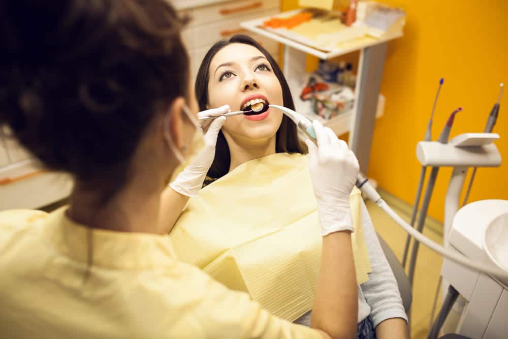 Dentist performing teeth cleaning in a Dubai clinic, showcasing the step-by-step process.