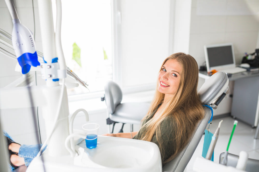 A smiling patient in the dentist's chair after a professional cleaning