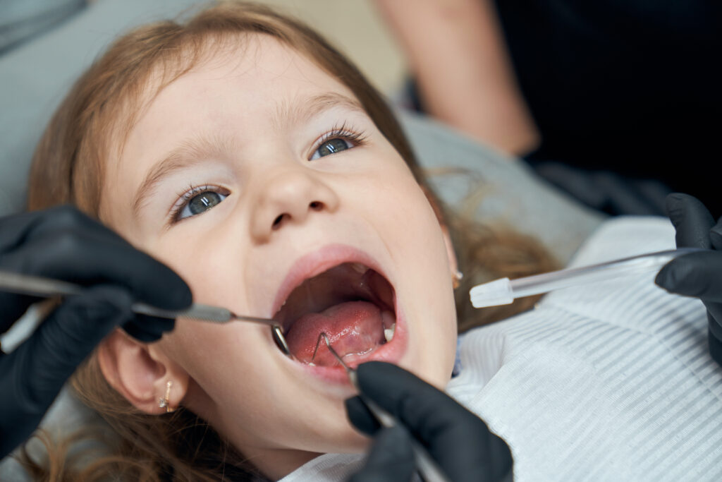 Dentist checking a child's teeth before Invisalign First treatment
