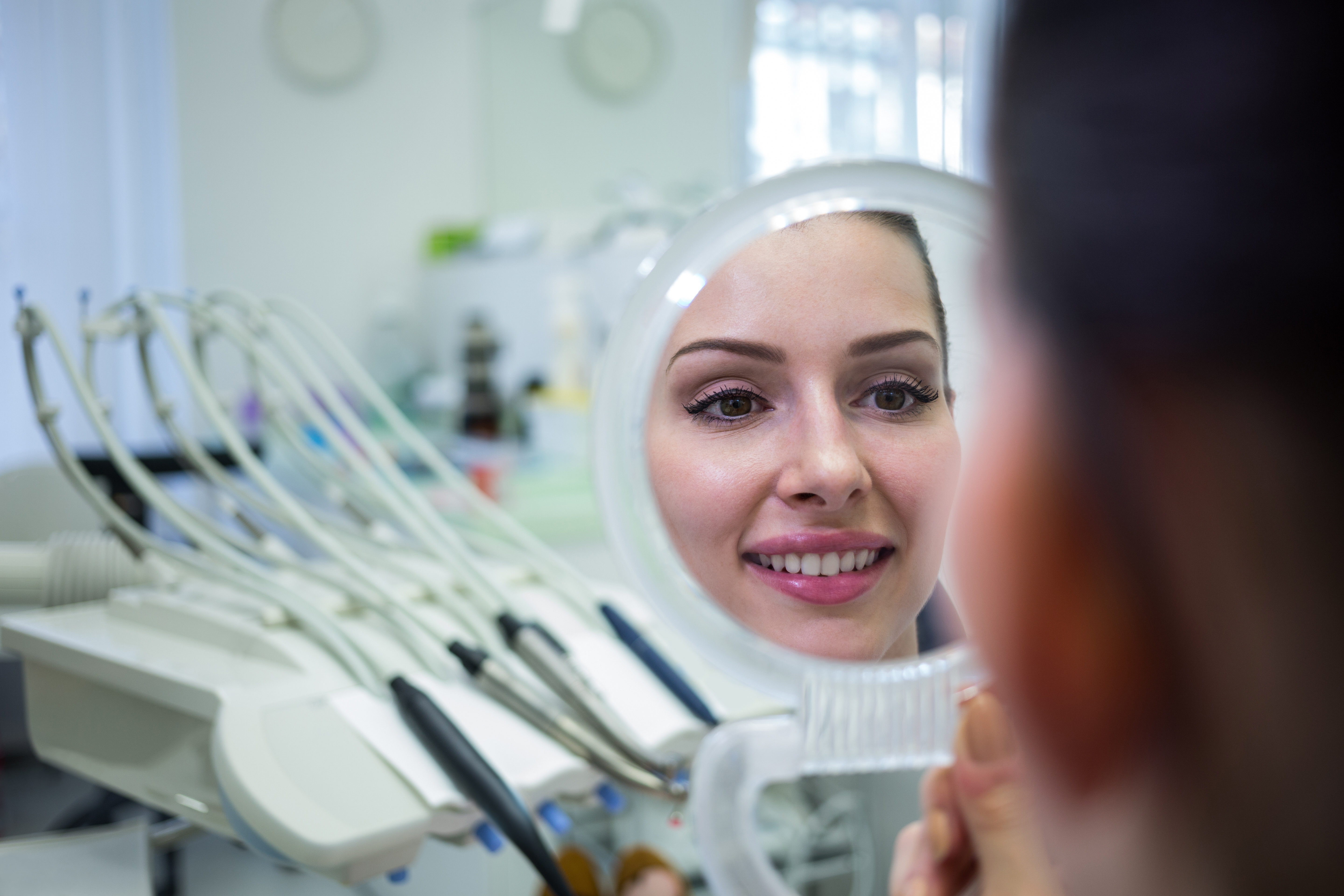 Patient comparing teeth shade for home whitening at Mint Dental Care